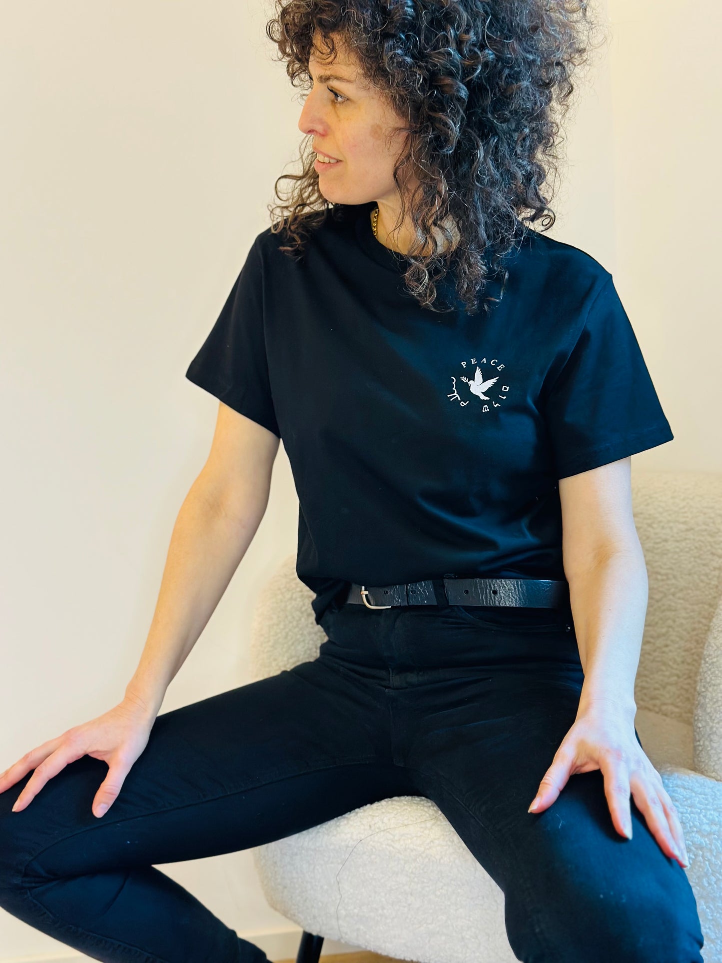 woman wearing black T-shirt with peace written in Hebrew and Arabic
