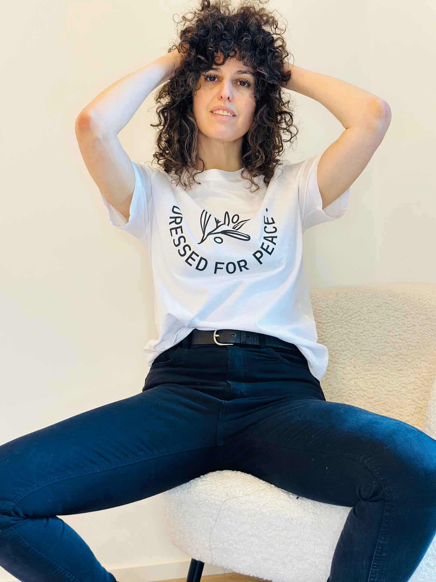 woman wearing white shirt with dressed for peace logo on it