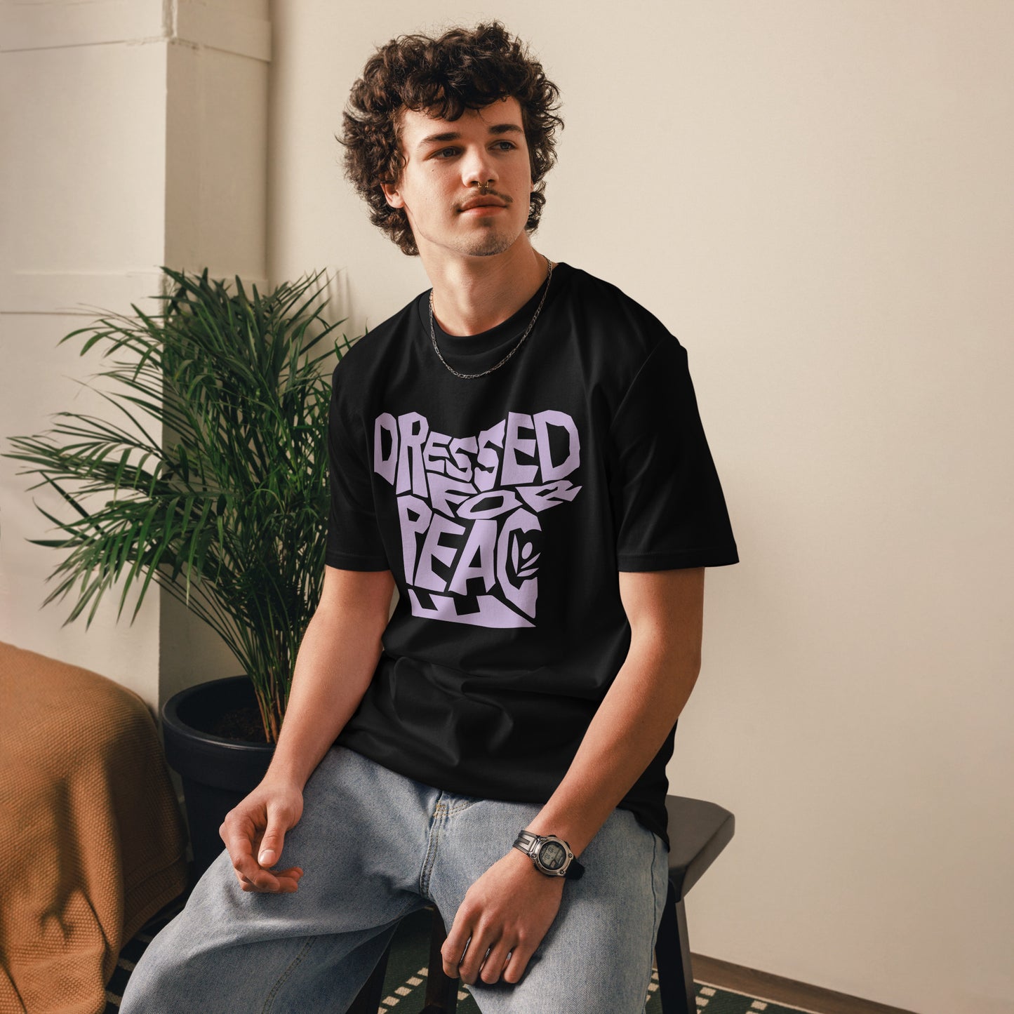 Person wearing a black t-shirt with 'Dressed for Peace' text, sitting indoors.