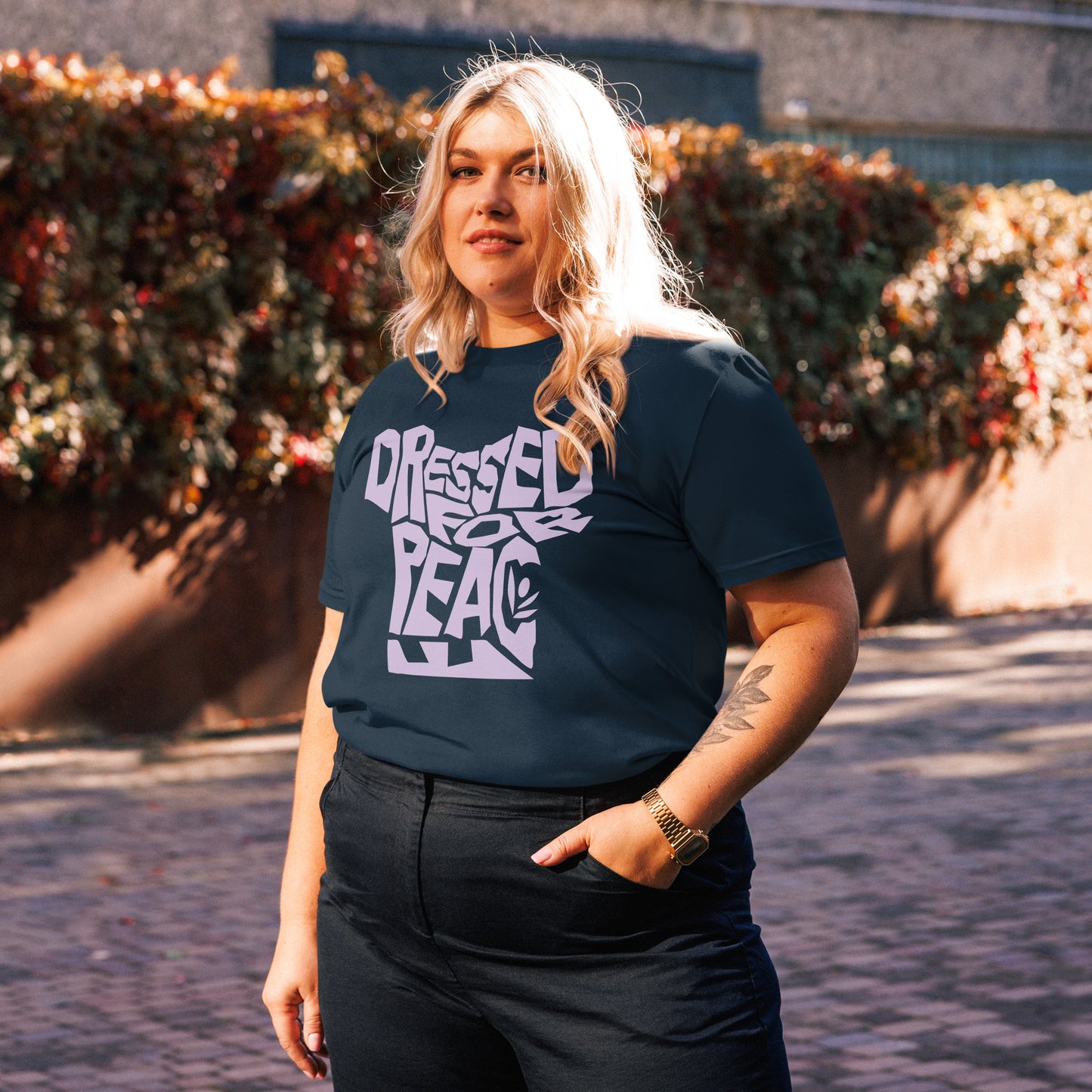 Person wearing a black t-shirt with white text standing outdoors.