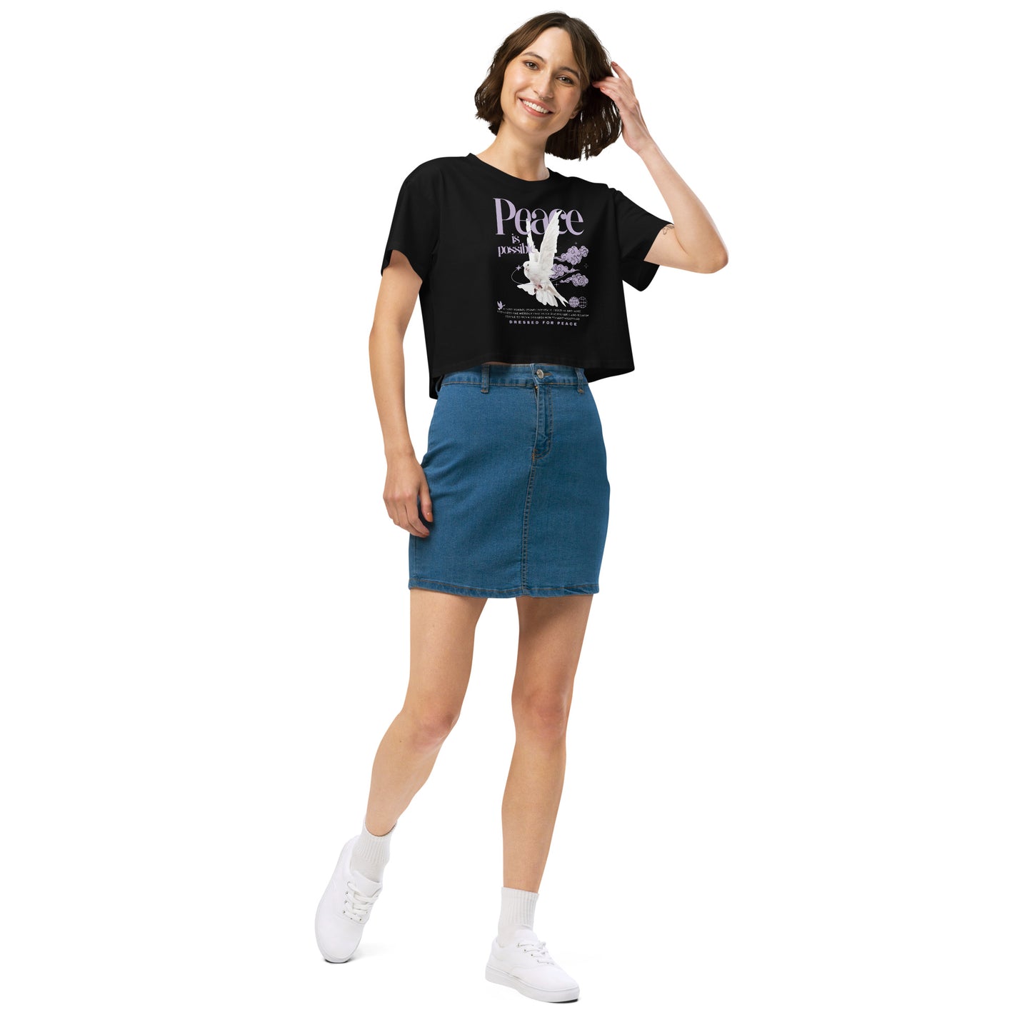 Woman wearing a black t-shirt with a graphic design and a blue denim skirt on a white background
