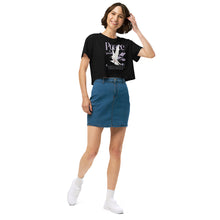 Woman wearing a black t-shirt with a graphic design and a blue denim skirt on a white background