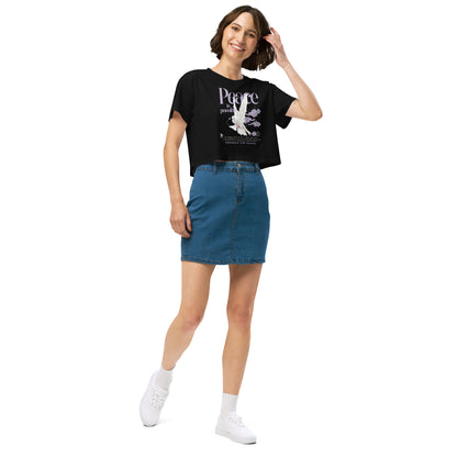 Woman wearing a black t-shirt with a graphic design and a blue denim skirt on a white background